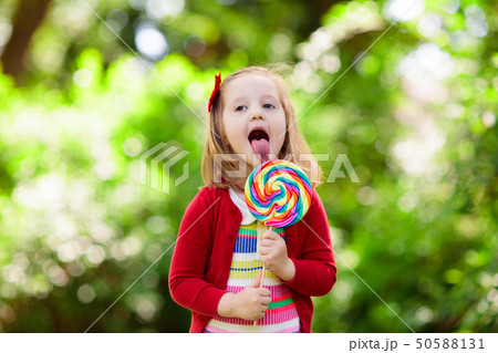 Little girl with colorful candy lollipop 50588131