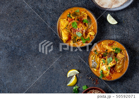 INDIAN FOOD. Traditional KERALA FISH CURRY with naan bread, gray plate, black background  50592071