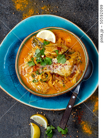 INDIAN FOOD. Traditional KERALA FISH CURRY with naan bread, gray plate, black background  50592099