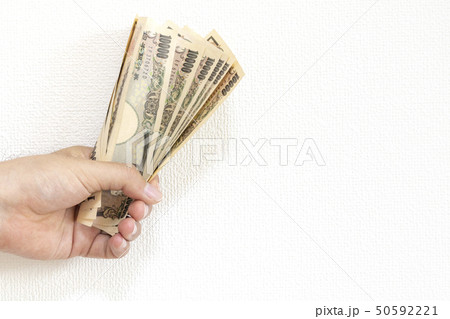 日本のお札を握る男の手の写真素材