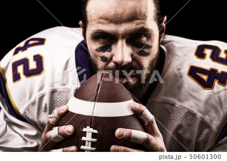 Portrait close-up, American football player, bearded without a helmet with the ball in his hands Portrait close-up, American football player, bearded without a helmet with the ball in his hands 50601300