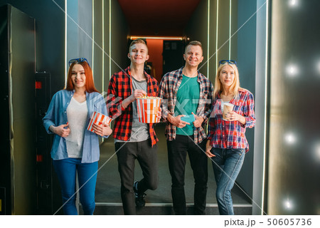 Teenagers with popcorn poses in cinema hall 50605736
