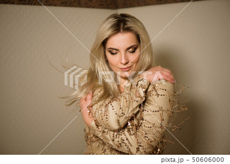 Plus the size of a woman in a gold dress posing Plus the size of a woman in a gold dress posing 50606000