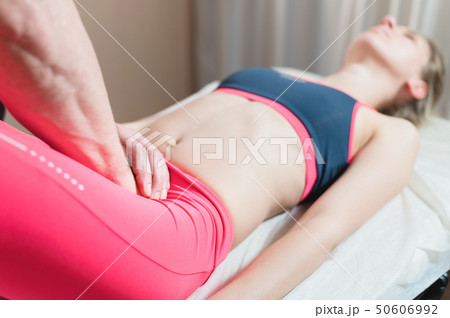 Male manual visceral therapist masseur treats a young female patient. External editing of the uterus 50606992