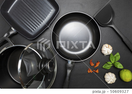 Top view frying pan and pot on black leather 50609327