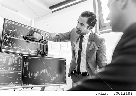 Stock brokers looking at computer screens, trading online. Stock brokers looking at computer screens, trading online. 50612182