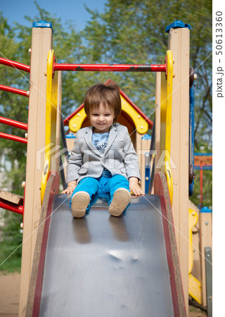 boy on the playground rolls down a hill boy on the playground rolls down a hill 50613360