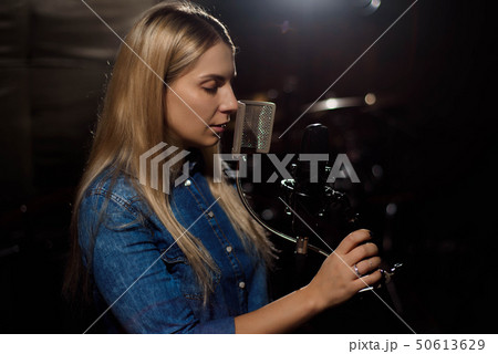 Blonde singing woman in a recording studio 50613629