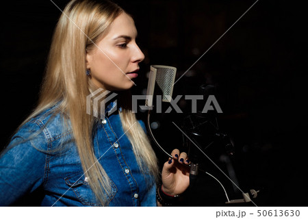 Blonde singing woman in a recording studio 50613630