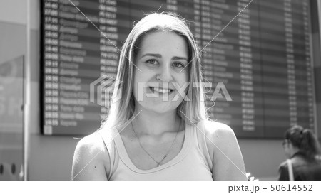 Black and white portrait of beautiful smiling woman posing in airport terminal before flight Black and white portrait of beautiful smiling woman posing in airport terminal before flight 50614552