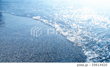 Closeup image of blue sea waves rolling over sandy beach. Abstract out of focus image 50614920