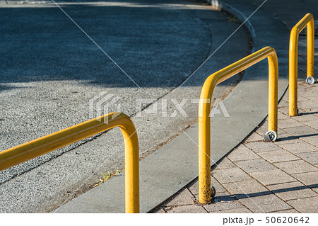 ロータリーに設置された交通安全用の黄色いガードポールの写真素材