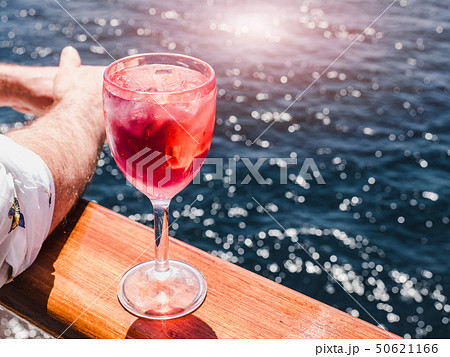 Wineglass with a pink cocktail and ice cubes 50621166