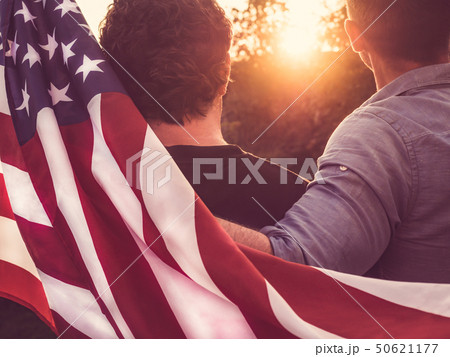 Two friends hold American Flag at sunset Two friends hold American Flag at sunset 50621177