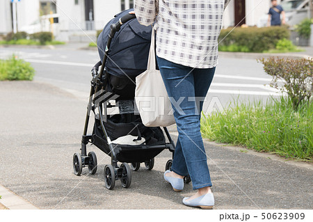 ベビーカーを押す母親の後ろ姿 住宅街 外出 子育て ベビーカーを押す母親の後ろ姿 住宅街 外出 子育て 50623909