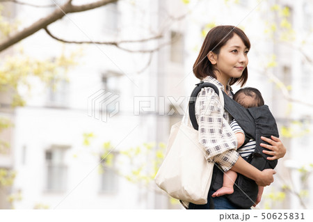 赤ちゃんを抱く母親　新緑　公園　屋外　抱っこ紐 50625831