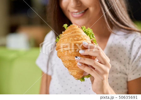 Selective focus of female hand keeping croissant  50635691