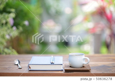 White coffee cup and notebooks on wooden table White coffee cup and notebooks on wooden table 50636278