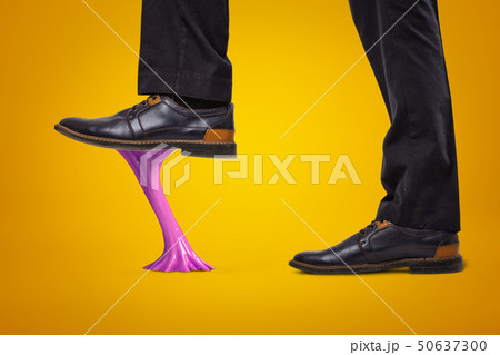 Violet bubble gum stuck to businessman shoes on yellow background Violet bubble gum stuck to businessman shoes on yellow background 50637300