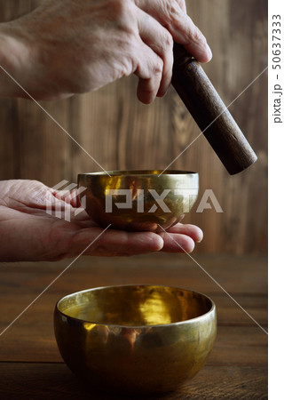 Male hand playing on Tibetan singing bowls Male hand playing on Tibetan singing bowls 50637333