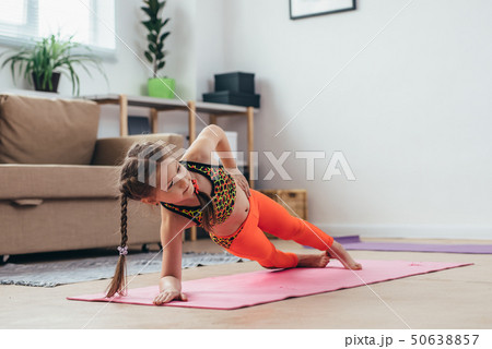 Little girl doing plank exercise at home. Little girl doing plank exercise at home. 50638857