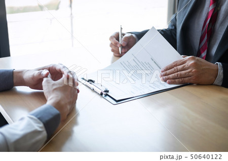 Employer or recruiter holding reading a resume Employer or recruiter holding reading a resume 50640122