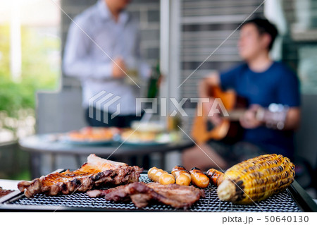 Group of friends Two young man enjoying grilled Group of friends Two young man enjoying grilled 50640130