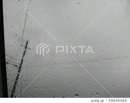 雨の水滴がつくガラス窓と曇り空 50640369