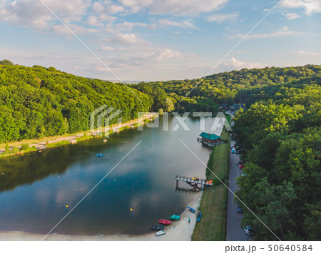 aerial view of resort near lake forest around. people on boats and catamarans 50640584