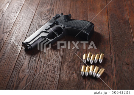 illegal handgun on wooden table 50643232