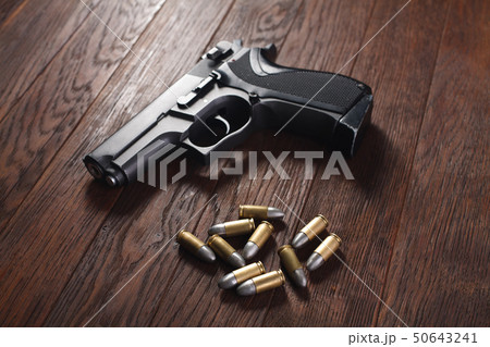 illegal handgun on wooden table 50643241