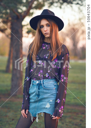 Beautiful girl in a denim skirt and a transparent blouse. Beautiful girl in a denim skirt and a transparent blouse. 50643704