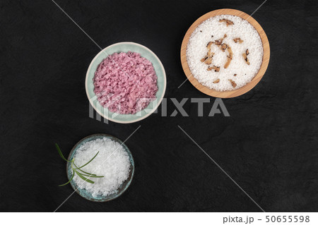 Gourmet spices. Various types of finishing salt, shot from above on a black background with copy 50655598