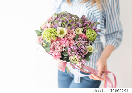 cute bouquet of mixed flowers in womans hands. the work of the florist at a flower shop. Delicate cute bouquet of mixed flowers in womans hands. the work of the florist at a flower shop. Delicate 50660291