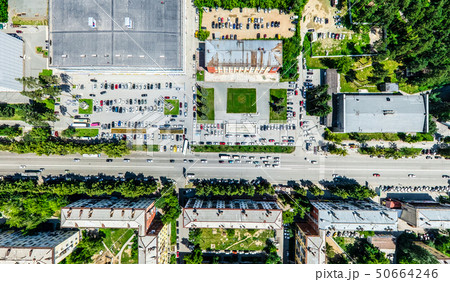 Aerial city view with crossroads and roads, houses, buildings, parks and parking lots. Sunny summer Aerial city view with crossroads and roads, houses, buildings, parks and parking lots. Sunny summer 50664246