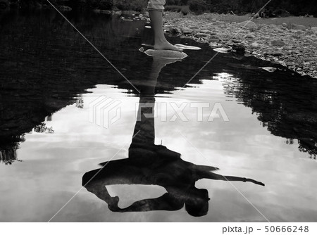 Woman performing yoga on a rock in a mountain river Woman performing yoga on a rock in a mountain river 50666248