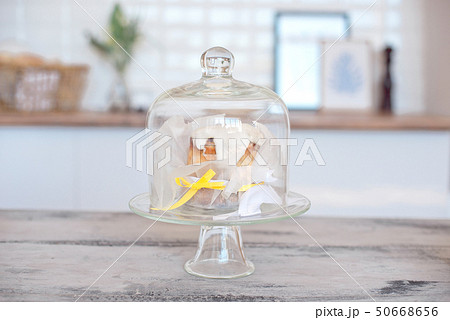 Glass cap for the cake stand is on a white table in a bright room 50668656