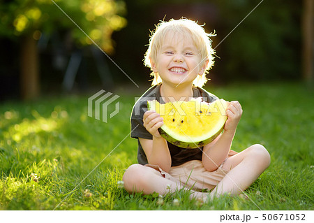 Cute caucasian little boy eating yellow watermelon 50671052