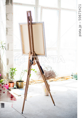 Easel with canvas standing in empty artistic studio Easel with canvas standing in empty artistic studio 50673421