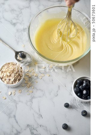 Mixing eggs,flour and milk in bowl with wire whisk Mixing eggs,flour and milk in bowl with wire whisk 50673601
