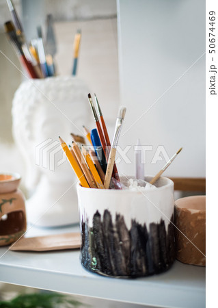 Pencils and brushes on shelf in artistic studio Pencils and brushes on shelf in artistic studio 50674469