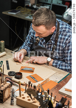 Concept of handmade craft production of leather goods. Concept of handmade craft production of leather goods. 50674740
