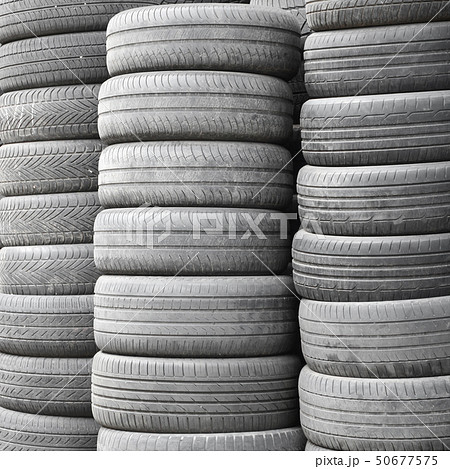 Old used tires stacked with high piles in 50677575