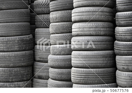 Old used tires stacked with high piles in 50677576