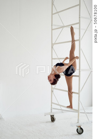 The splits in the air on metal poles.Gymnast in black tights. Flexibility 50678100