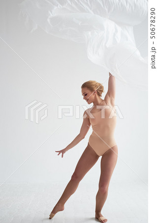 Gymnast dancing with a transparent film on a white wall and floor.Grace and healthy lifestyle. Gymnast dancing with a transparent film on a white wall and floor.Grace and healthy lifestyle. 50678290
