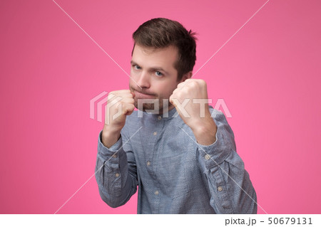 Strong young caucasain man in fighting stance with fists, attacks or protects his family. 50679131