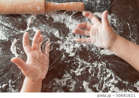 hands of a small child palms up on a table with flour and rolling pin hands of a small child palms up on a table with flour and rolling pin 50681621