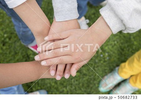 屋外で円陣を組む小学生手元の写真素材