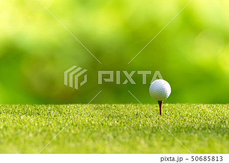 Golf ball approach to the tee off on the green 50685813